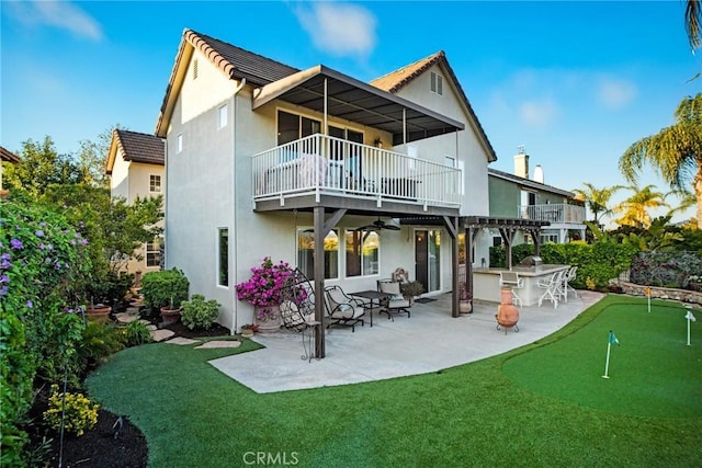 26238 Beecher Ln, Stevenson Ranch, CA 91381 - back of house with a balcony, a putting green, a patio, stucco siding, and a ceiling fan