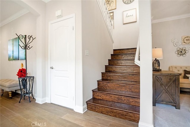stairs featuring arched walkways, wood finished floors, and ornamental molding