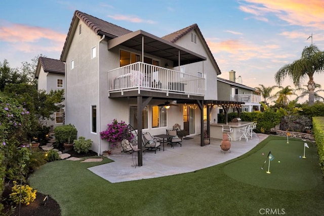 back of property with a patio, stucco siding, a balcony, and outdoor dry bar