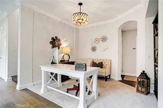 office space with crown molding, arched walkways, wood finished floors, baseboards, and a chandelier