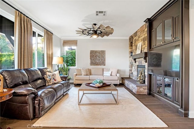 living area featuring visible vents, a ceiling fan, crown molding, and dark wood-style floors