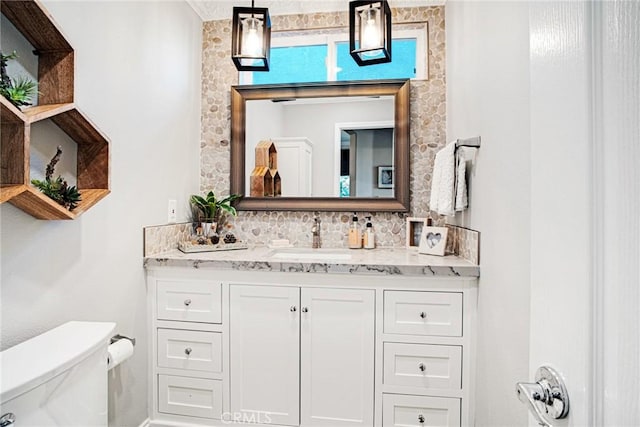 bathroom with toilet, tasteful backsplash, and vanity