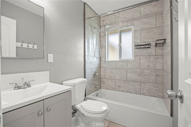 bathroom with shower / bath combination, vanity, a textured wall, and toilet