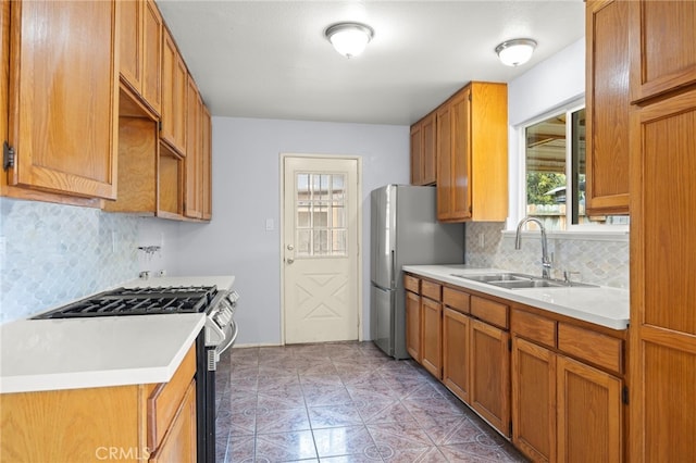 kitchen with a sink, appliances with stainless steel finishes, decorative backsplash, and light countertops