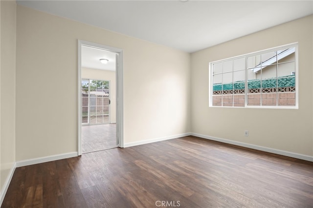 empty room with baseboards and wood finished floors