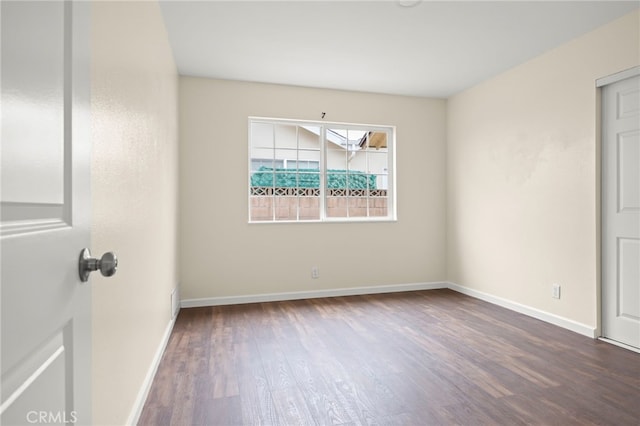 empty room featuring baseboards and wood finished floors