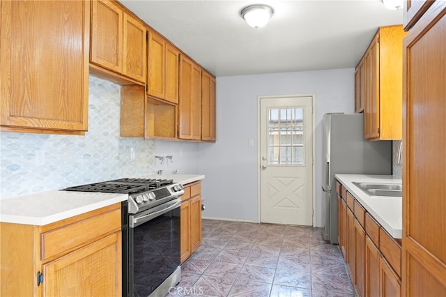 kitchen with light countertops, stainless steel gas range oven, and tasteful backsplash