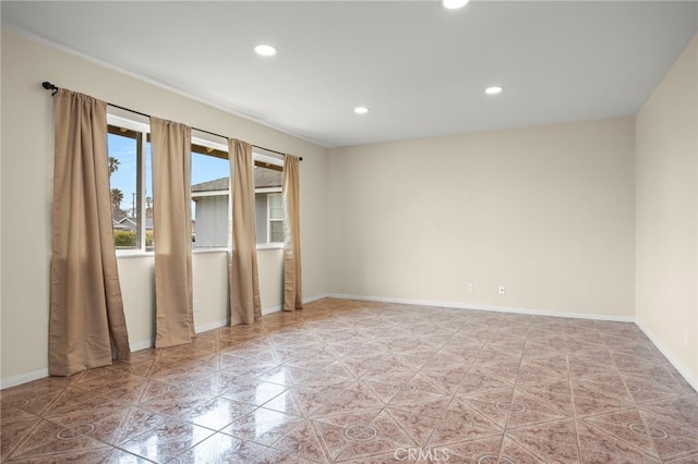 empty room featuring recessed lighting and baseboards