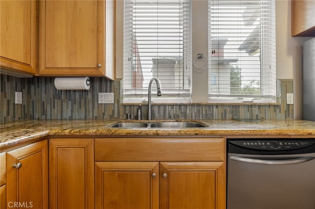 1210 Southwood Dr, San Luis Obispo, CA 93401 - kitchen featuring stainless steel dishwasher, brown cabinetry, light stone counters, a sink, and backsplash