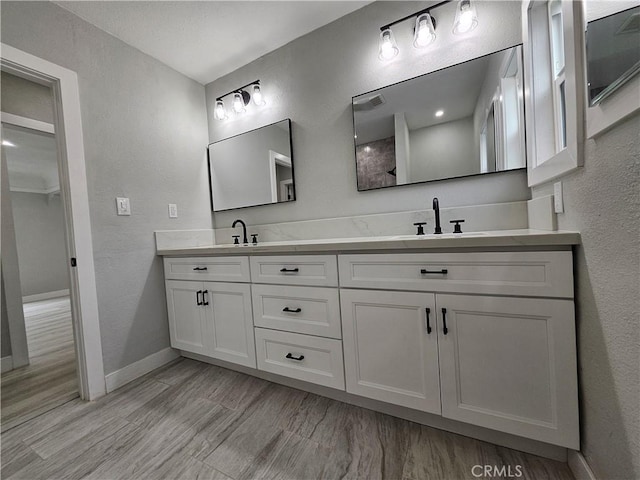3612 Liberty Blvd, South Gate, CA 90280 - bathroom featuring double vanity, a textured wall, baseboards, and wood finished floors