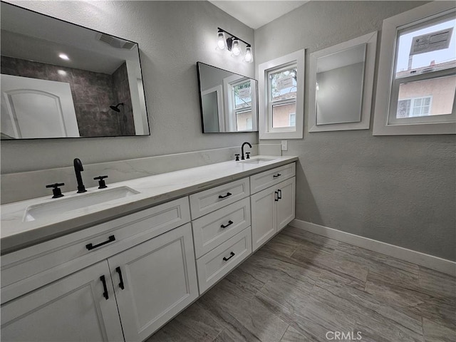 3612 Liberty Blvd, South Gate, CA 90280 - bathroom with plenty of natural light, double vanity, a textured wall, baseboards, and tiled shower