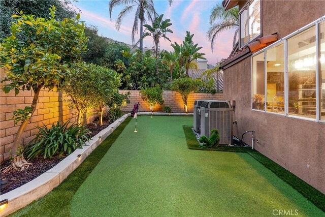 1720 San Alvarado Cir, Corona, CA 92882 - yard at dusk with cooling unit, a putting green, and a fenced backyard