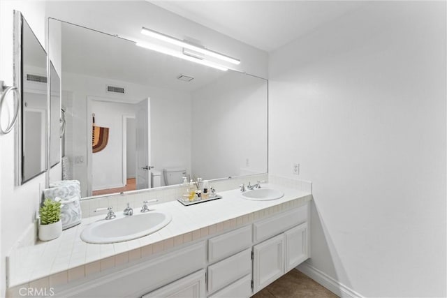 1720 San Alvarado Cir, Corona, CA 92882 - bathroom featuring toilet, double vanity, baseboards, and tile patterned floors