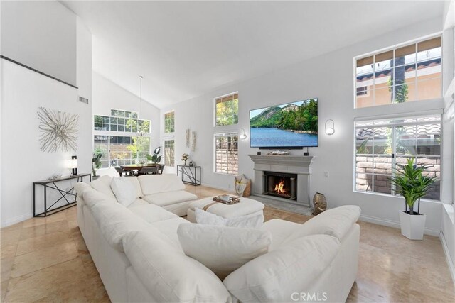 1720 San Alvarado Cir, Corona, CA 92882 - living room featuring high vaulted ceiling, a warm lit fireplace, healthy amount of natural light, and baseboards