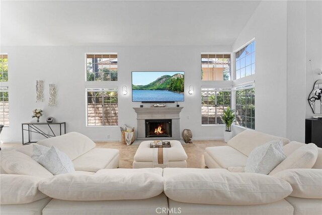1720 San Alvarado Cir, Corona, CA 92882 - living room featuring a lit fireplace, baseboards, and a towering ceiling
