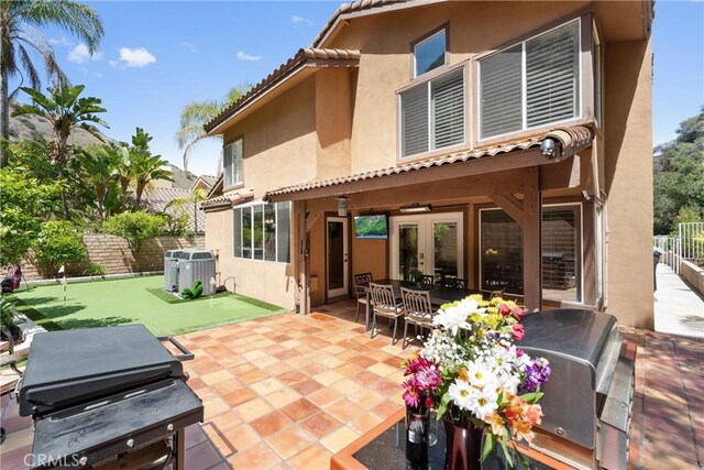 1720 San Alvarado Cir, Corona, CA 92882 - rear view of house with an area to practice putting, stucco siding, a patio, and fence
