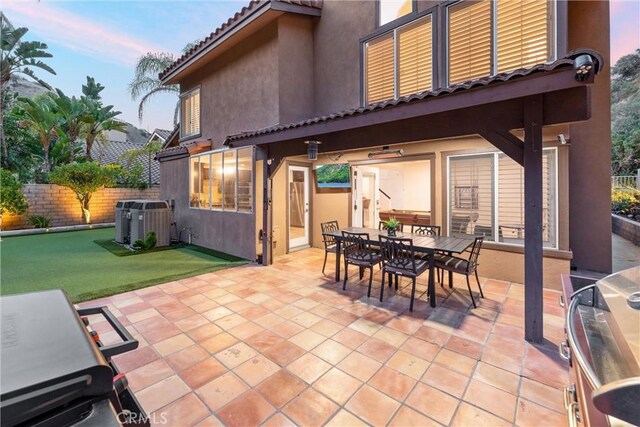 1720 San Alvarado Cir, Corona, CA 92882 - patio terrace at dusk with outdoor dining area, central air condition unit, and fence