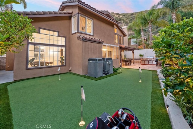 1720 San Alvarado Cir, Corona, CA 92882 - back of property with a putting green, a patio area, fence, and stucco siding