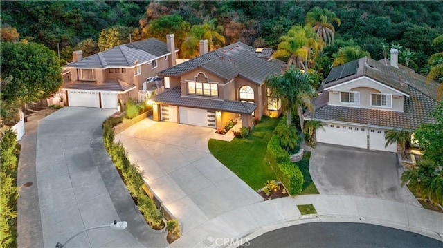 1720 San Alvarado Cir, Corona, CA 92882 - view of front of property with a tiled roof, driveway, roof mounted solar panels, stucco siding, and a garage