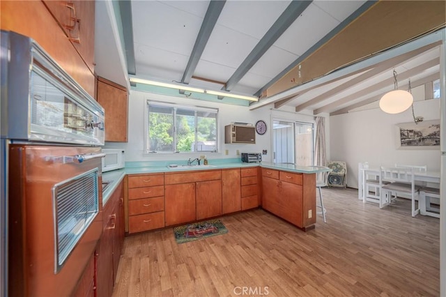 6828 Frontage Rd, Lucerne, CA 95458 - kitchen featuring light countertops, a sink, lofted ceiling with beams, white microwave, and a peninsula