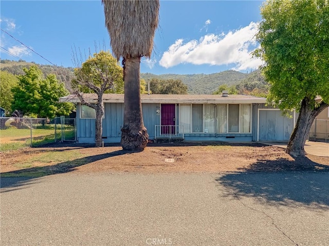 6828 Frontage Rd, Lucerne, CA 95458 - ranch-style home featuring fence, a mountain view, and board and batten siding