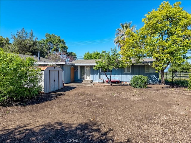 6828 Frontage Rd, Lucerne, CA 95458 - rear view of house featuring board and batten siding, fence, an outbuilding, and a storage unit