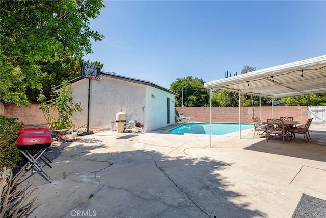 view of pool featuring a grill, a fenced backyard, a fenced in pool, a patio area, and outdoor dining space