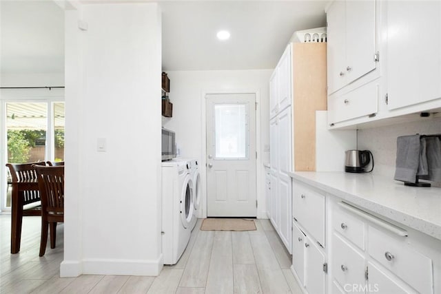laundry area with baseboards, recessed lighting, cabinet space, light wood-style flooring, and independent washer and dryer