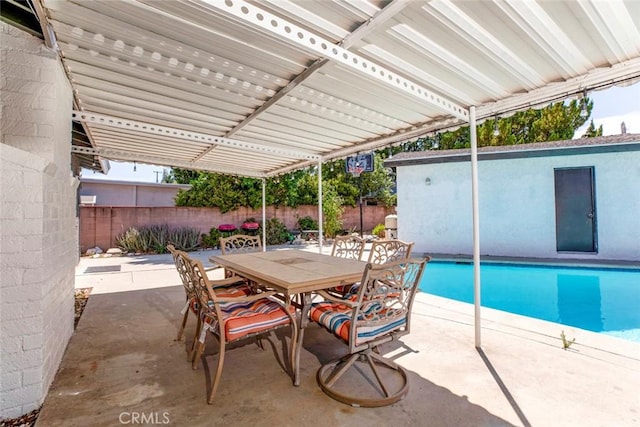 exterior space featuring a fenced in pool, outdoor dining area, and fence
