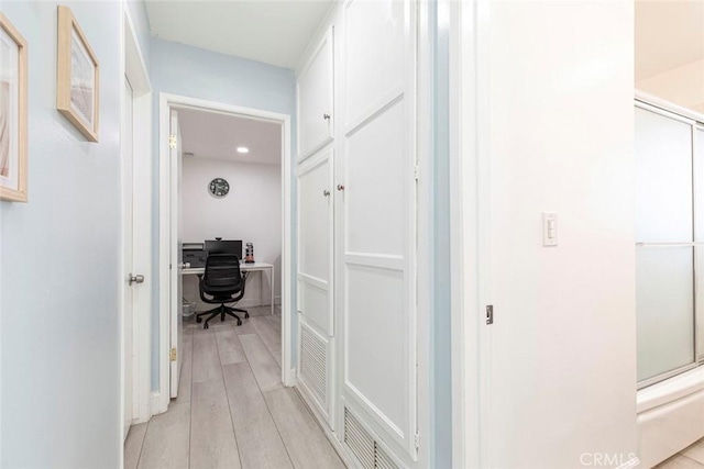 hall with light wood-style floors and recessed lighting