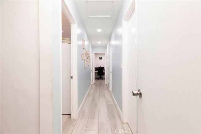 corridor featuring baseboards, recessed lighting, and light wood-style flooring