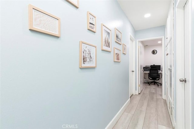 corridor with recessed lighting, baseboards, and light wood-style floors