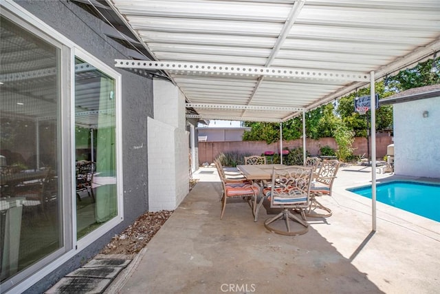view of patio / terrace with outdoor dining area, a fenced backyard, and a fenced in pool