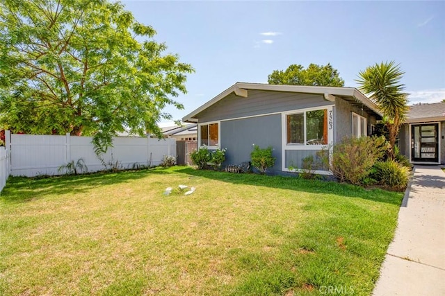 exterior space with fence and a yard