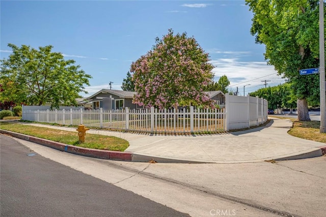 view of property hidden behind natural elements featuring a fenced front yard