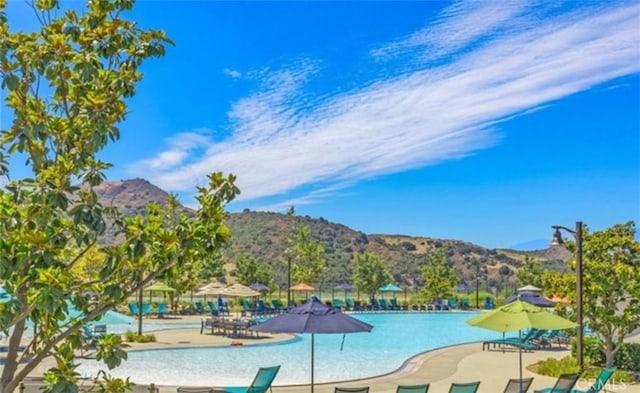 pool with a mountain view and a patio area