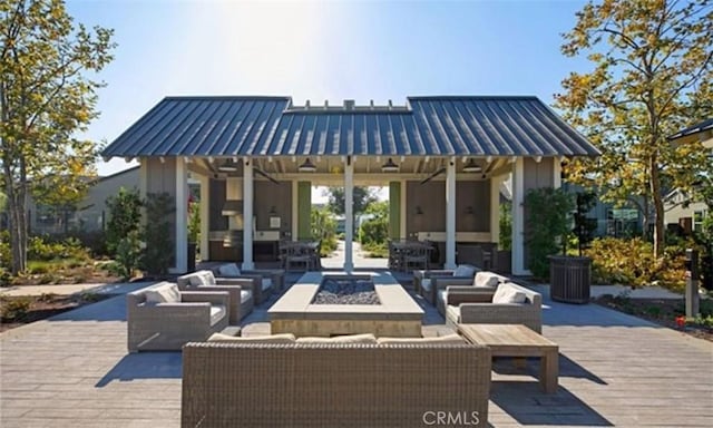 view of patio with an outdoor living space with a fire pit and a wooden deck