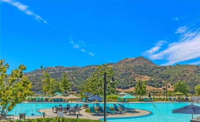 pool with a mountain view and a patio area