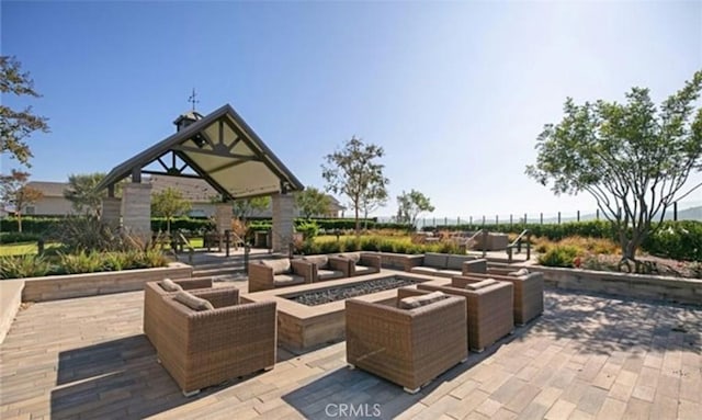 view of patio with an outdoor living space with a fire pit