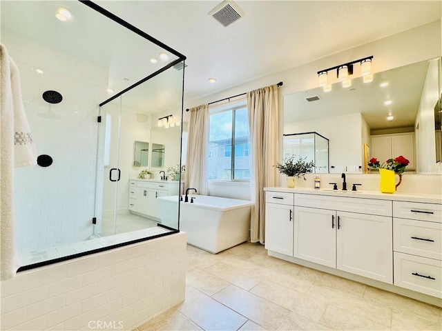 bathroom featuring a freestanding bath, vanity, a shower stall, and visible vents