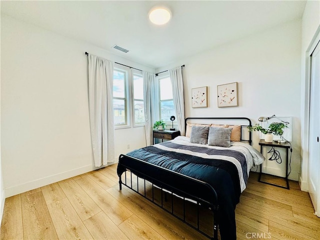 bedroom with visible vents, baseboards, and light wood-type flooring