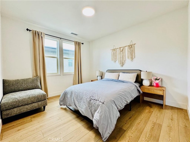 bedroom with baseboards, visible vents, and light wood-style floors