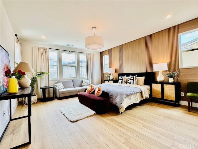 bedroom featuring multiple windows, light wood-type flooring, and visible vents