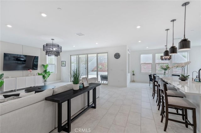 living area featuring a healthy amount of sunlight, recessed lighting, light tile patterned flooring, and visible vents