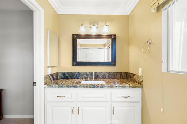 bathroom featuring vanity, baseboards, and crown molding