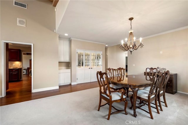 dining space with visible vents, ornamental molding, baseboards, and a notable chandelier