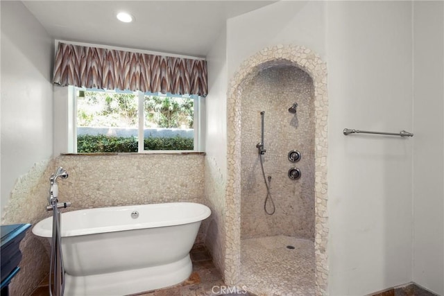 full bathroom with a walk in shower, recessed lighting, and a freestanding tub