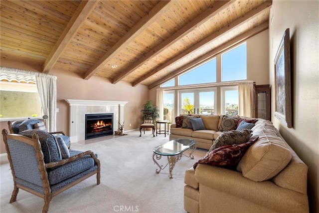 carpeted living area featuring beamed ceiling, high vaulted ceiling, a fireplace with flush hearth, and wooden ceiling