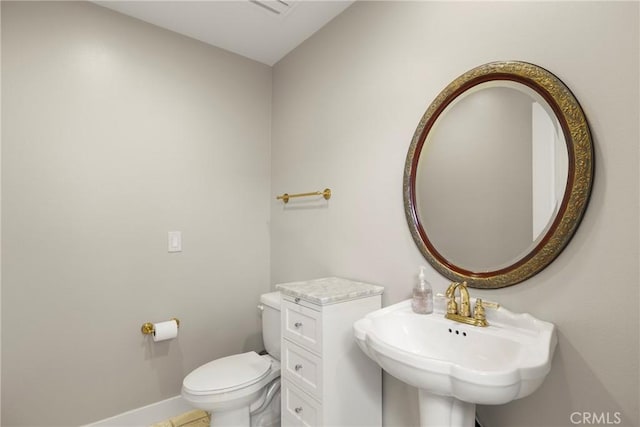 bathroom featuring toilet, baseboards, a sink, and tile patterned flooring