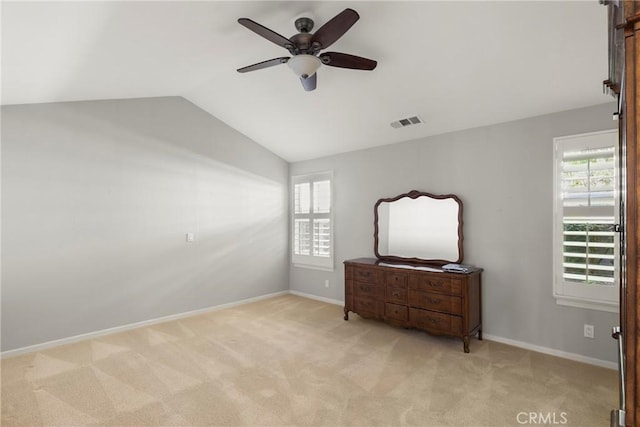 unfurnished bedroom with visible vents, vaulted ceiling, and light carpet